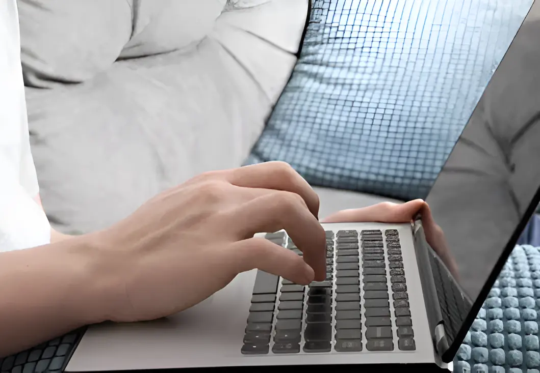 A person typing on a laptop computer.