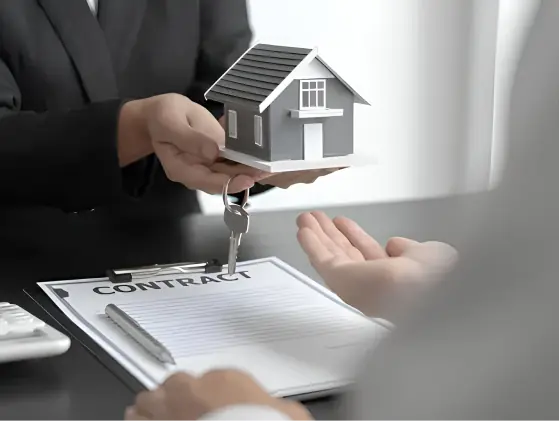 A person holding a house key over a contract.