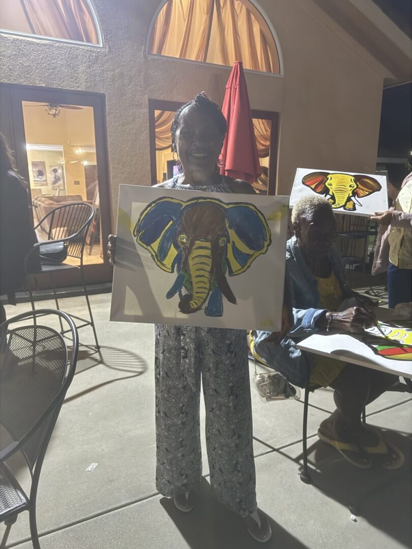 A person holding up an elephant painting