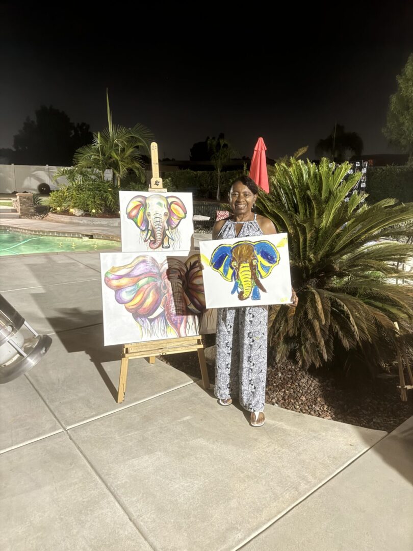 A person standing next to two paintings on canvas.