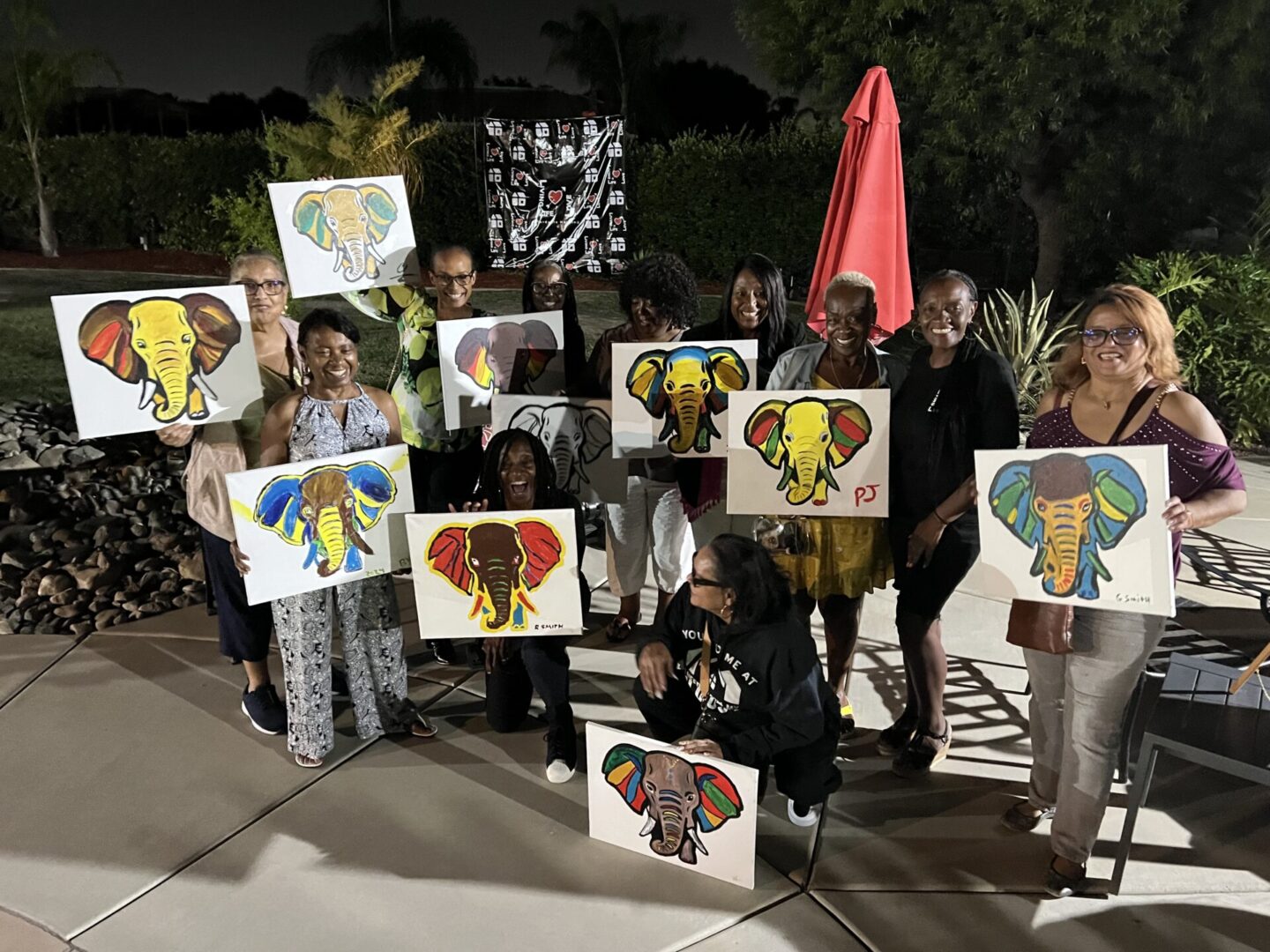 A group of people holding up signs with elephants on them.