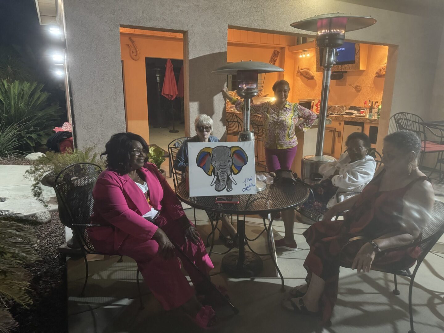 A group of people sitting around an outdoor table.