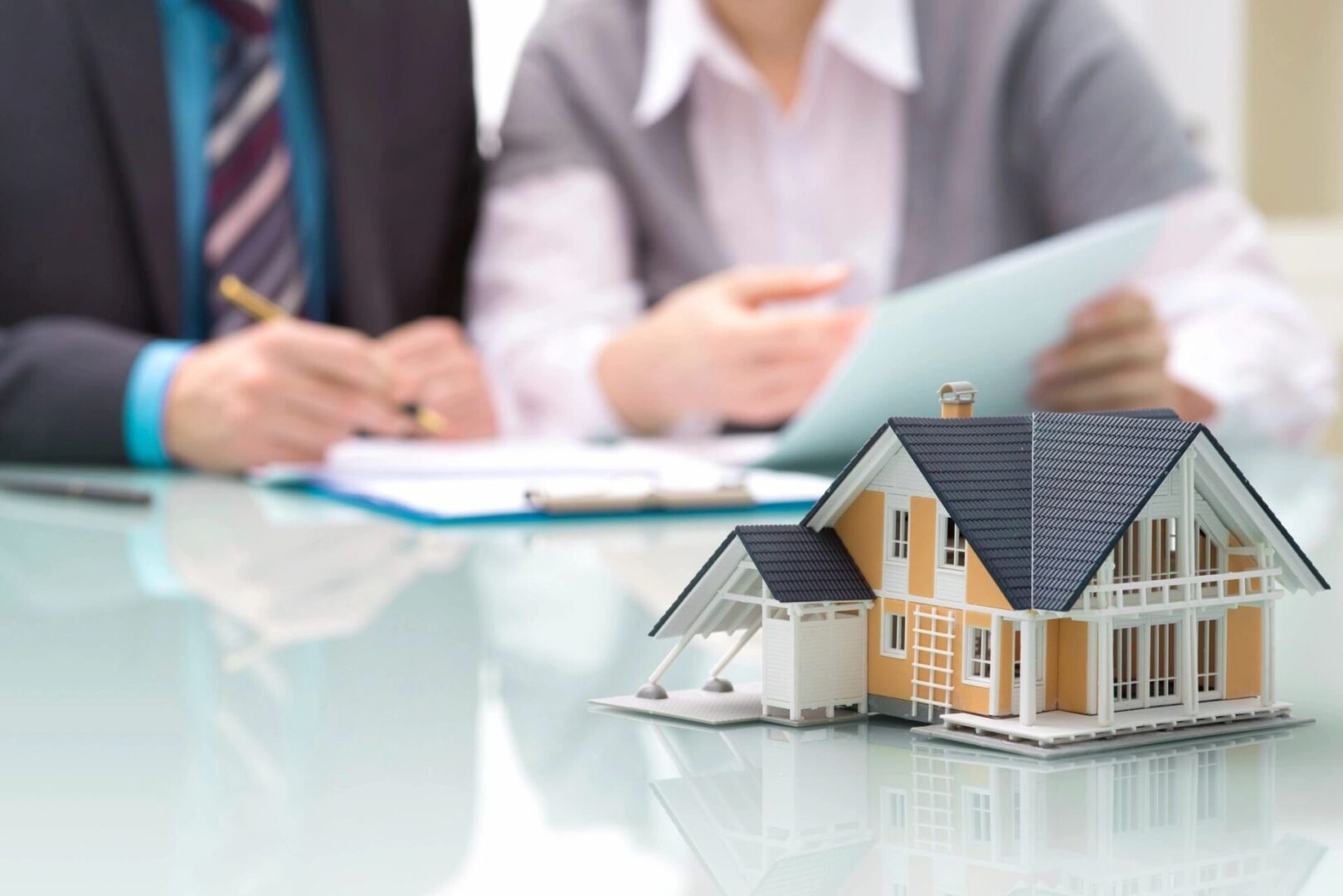 A couple of people sitting at a table with some houses.